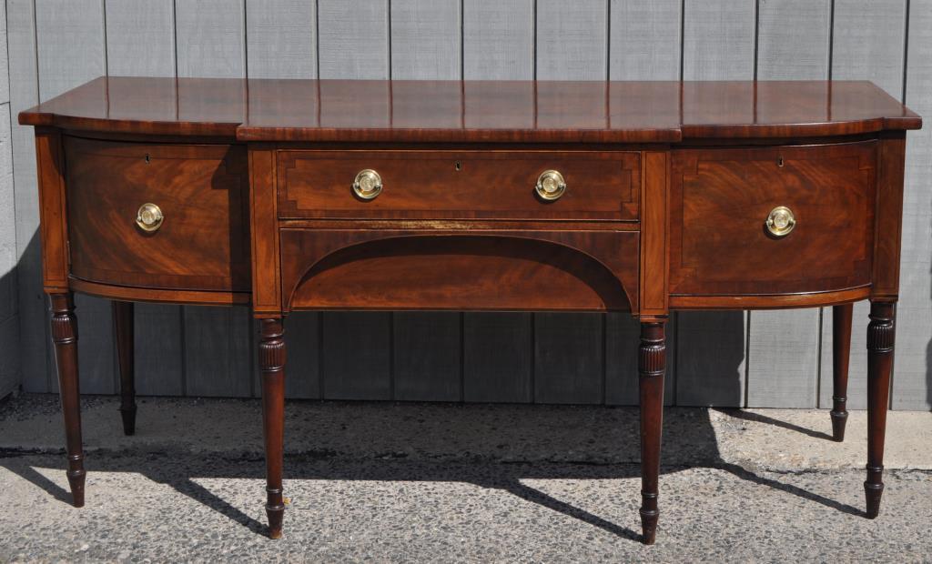 George III Mahogany Sideboard: with "Admiral Lord Nelson Duke of Bronti" pulls with Lord Nelson's bust. 37 1/8" high, 79 3/8" wide, 31 1/8" deep. Age and use wear, splitting, losses, scuffing, fading, gouging, staining.
