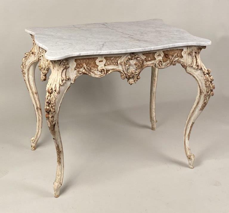 Continental M/T Baroque Paint/Gilt Center Table: serpentine four sided design, with later conforming shaped marble, carved aprons and cabriole legs. 30 1/2" high, 42 1/2" wide, 28 1/4" deep. Paint and gilt wear, some restorations, later metal bracin