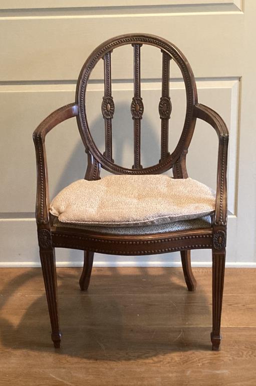 George III Oval Back Carved Mahogany Arm Chair: with elaborate carving and beadwork details. 36 3/4" high, 23 1/8" wide, 19" deep; seat height 18". Repairs, age and use wear, light nicks, veneer loss in oval. Property from the Estates of Eve & Pete