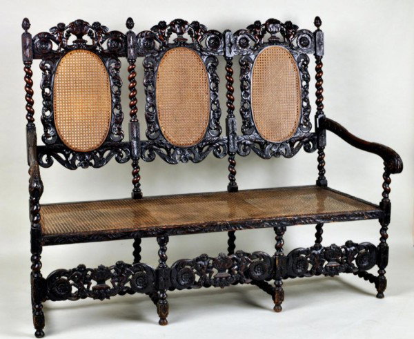 Charles II Style Triple Chair Back Settee: Charles II style triple chair back settee, each pierced foliate carved crest with rosette terminals centering putting flanking an overflowing urn, over caned oval back panels within foliate and floral