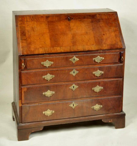 George II Walnut Slant Front Desk 18th C.: Georgian walnut veneered slant front desk with fitted interior and leather inset writing board above four graduated thumb molded drawers set on bracket feet. Some restorations. England, early 18th cen