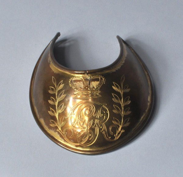 Brass "Gorget" 18th/19th Century: Brass gorget with incised royal cipher and laurel leaves, England, 18th/19th century, split to top. 4" high, 3 1/4" wide, 1 1/2" deep.