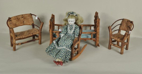 Four Pcs. Miniature Adirondack Doll Furniture: Four vintage miniature Adirondack doll furniture pieces -- settee, cradle, chair and rocker -- with newer bisque doll. Settee: 8" high, 9 1/2" wide, 5" deep; cradle: 8" high, 13" wide, 7 1/2" deep; ch