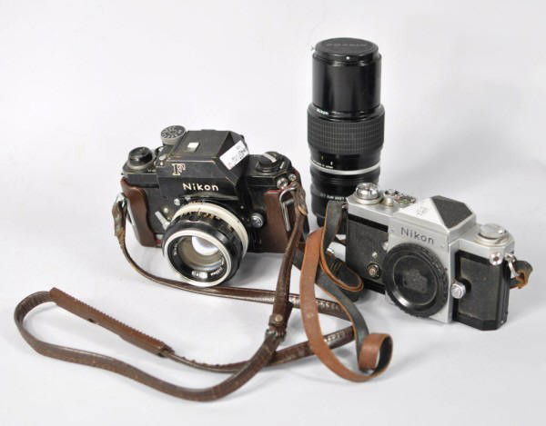 Two Nikon Cameras and Three Lenses: Two older Nikon 35 mm film cameras, both marked Nippon Kogaku, one with Nikkor-S 50 mm lens, the other with standard lens. Both have some wear from use, need cleaning and may need minor refurbishing.