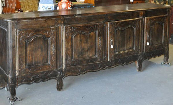 Substantial Louis XV Provincial Oak Buffet: A fine and substantial Louis XV provincial carved oak buffet enfilade, the thick rectangular top with molded edge over four paneled doors separated by foliate carving, the apron with similar vine and 