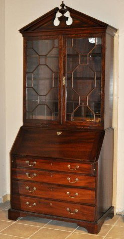 George III Pitch Pediment Secretary Desk: Fine George III carved mahogany secretary desk, with pitch pediment having carved molding, above 13 lite mullioned doors set on a slant lid base with fitted interior and graduated drawers, raised on b