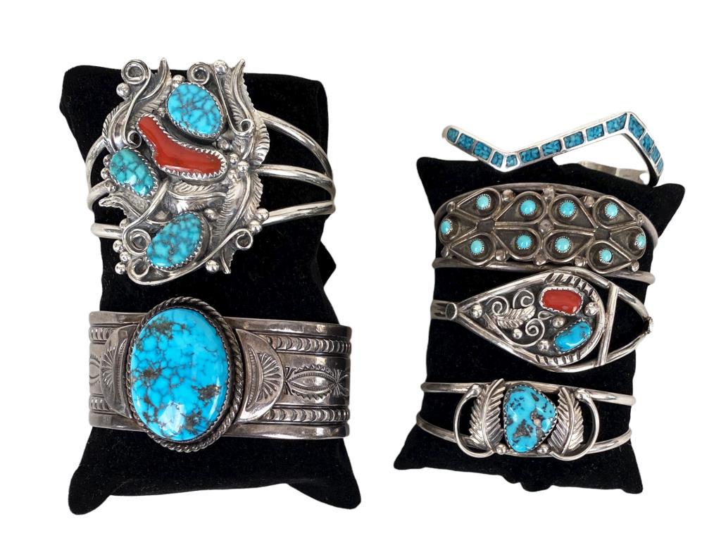 Group Six Native American Silver Bracelets: cuff bracelets, mostly turquoise, one with coral. Makers include: ESM (Ed Smith), DA Jim, I Yazzie, ? King, and Thomas J. Five marked sterling, one without purity stamp. Largest: 2" high, 2 1/2" wide,