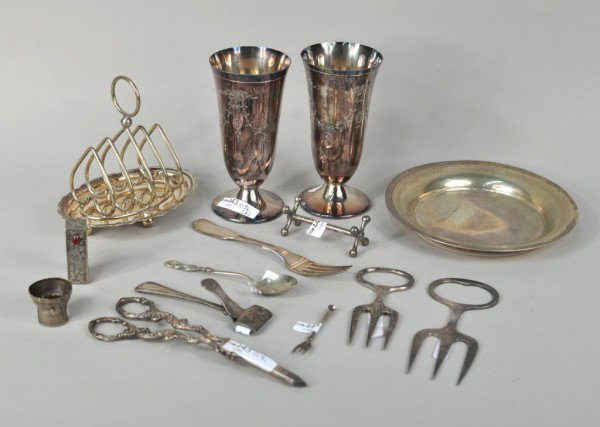 Group of Fifteen Assorted Silver Plated Items: Group of silver plated items comprising 2 beakers, knife rest, dish, spoon, fork, shears, extractor, lipstick case, miniature fork, magnifier, two meat forks, a toast rack and a silver plated coin pur