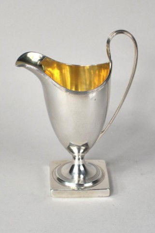 George III Silver Helmut-Shaped Cream Jug, 1795: George III silver helmet-shaped cream jug, Peter and Ann Bateman, London, 1795, on pedestal foot, with reeded rims and ear-shaped handle, gilt interior. 5.9 troy oz., 4 3/4" height to handle.