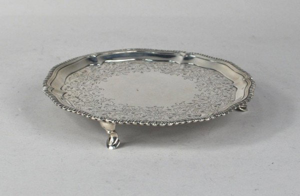 George III Silver Waiter, London 1768: George III silver waiter, John Cox, London, 1768, circular with shaped, gadrooned rim, on three hoofed feet, engraved with foliage and scrolls. 8.9 troy oz., 7 1/8" long.