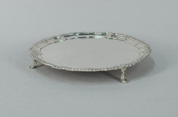 George III Irish Silver Salver, Dublin 1770: George III Irish silver salver, William Homer, Dublin, 1770, circular with shaped gadrooned rim, on three hoofed feet. 9.6 troy oz., 8" long. Bears initials "WFA" on underside of rim. Some slight bend