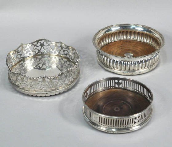 Three English Silver Wine Coasters, 19th C.: Three English silver wine coasters; the first George III by John Roberts & Co., Sheffield, 1807, with lobed sides, gadroon rim, wood base inset with circular plaque, engraved with crest; the second Vi