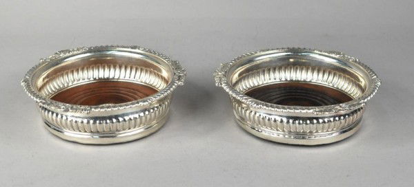 Pair of Old Sheffield Plated Wine Coasters: Pair of old Sheffield plated wine coasters, circa 1810, circular form, the gadrooned rims applied with shells and foliage, the wooden turned bases mounted with silver circular plaques. 6 1/2" diameter