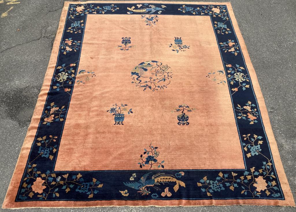 Room Size Chinese Art Deco Rug: with orange/rust colored field. 12' 10" long, 10' 7" wide. A few areas of wear, one hole as shown. All rugs sold as is.