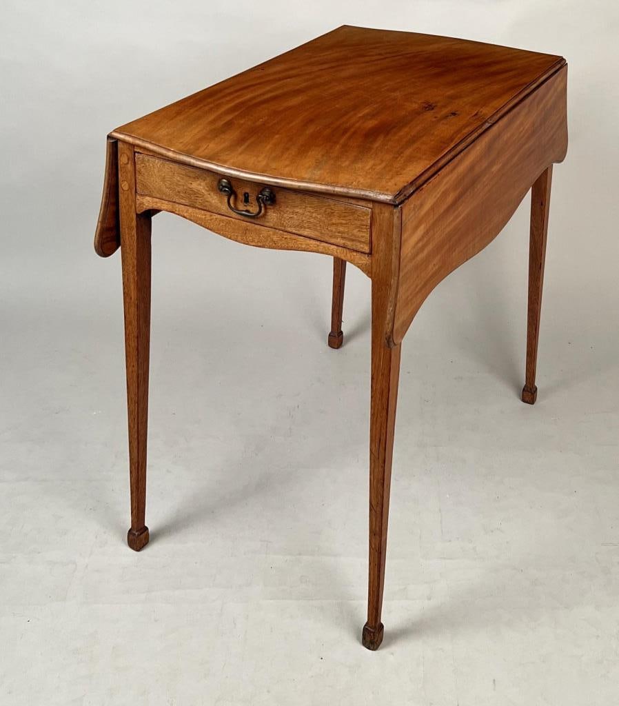 George III Faded Mahogany Pembroke Table: with serpentine top and aprons and one drawer, delicate tapered legs and spade feet. 28 1/4" high, 31" wide, 20 1/4" deep closed, 35 1/4" deep open. Some repairs, mostly to legs on one end.