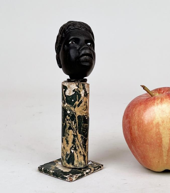 Carved Black Male Bust: on a marbleized papier mache base. With base: 5 1/2" high, 1 3/4" wide, 1 3/4" deep; bust: 2 1/4" high, 2 1/2" wide, 1 1/4" deep. Base with wear.