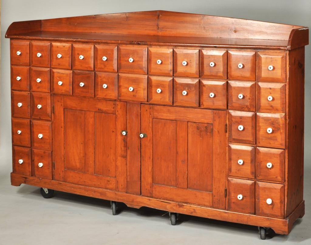 Large American Country Pine Apothecary Cupboard: Large country pine apothecary cupboard having a backsplash above two rows of 11 small drawers with beveled fronts, over a pair of cupboard doors flanked by 3 pairs of further drawers, American, 19th c
