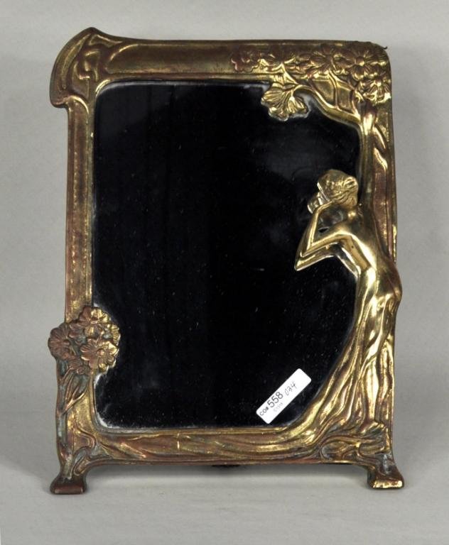Art Nouveau Gilt Brass Table Mirror: Art Nouveau gilt brass table mirror with rectangular mirror and frame depicting nature and a woman looking at her reflection. 13 1/2" high, 10" wide, 7 1/2" deep