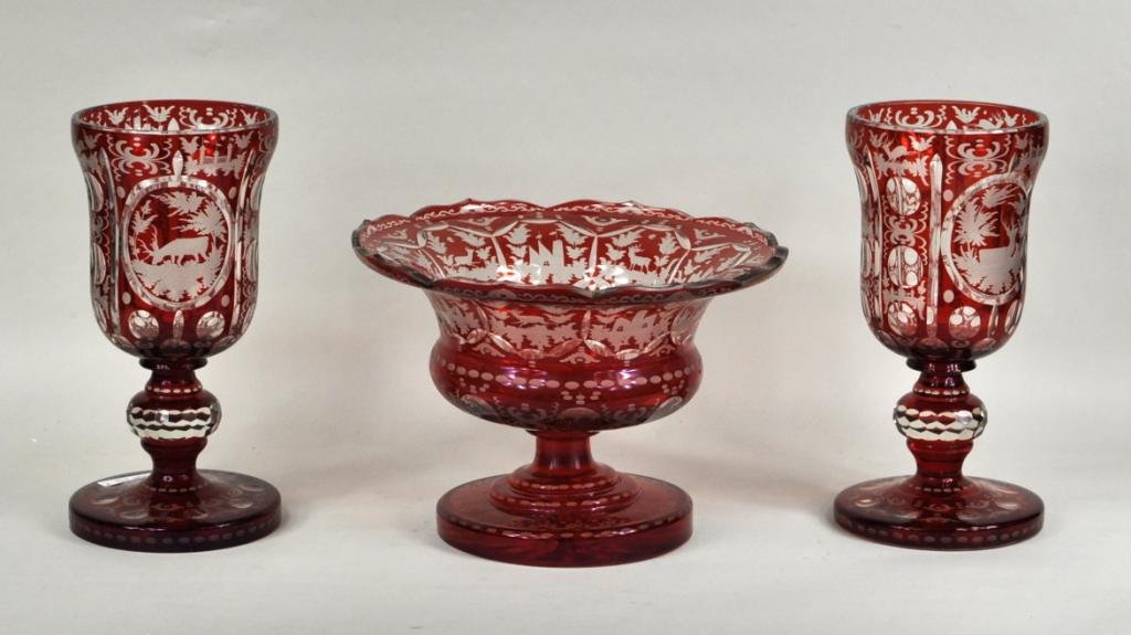 Cranberry Bohemian Cut to Clear Glass Garniture: Red Bohemian cut to clear three piece glass garniture set with bowl and two chalices having an etched stag pattern. (3 pieces total) Large: 7 1/4" high, 10 3/4" diameter; small: 10 1/4" high, 5 1/4" d