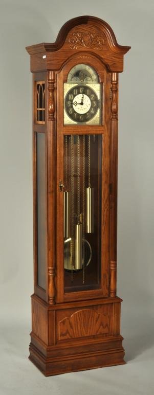 Ridgeway Oak Cased Grandfather Clock: Ridgeway oak grandfather clock, with arched bonnet, turned and reeded pilasters, brass dial with moon phases, and lyre form pendulum. Includes original owner's manual. 79 1/2" high, 20 1/2" wide, 12" 