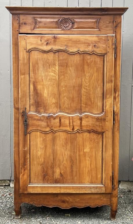 French Provincial Fruitwood Armoire: with removable cornice. One door, carved frieze above. 81 1/4” high, 44 3/4” wide, 23 1/4” deep. Expected age and use wear, restorations to back feet and tips of front feet.
