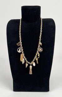 18K Gold Charm Necklace: eleven charms comprising windmill, scarab, St. Mark's lion, column, etc. Chain 18k, charms vary. Chain: 23 3/4" long. Gross weight: 47.7 DWT. *No credit card payments will be accepted for silver,