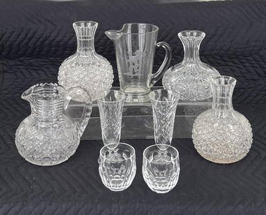 Estate Group Cut Glass, Including Decanters: comprising three American brilliant cut glass decanters with an American brilliant cut glass pitcher, engraved lion pitcher and four Waterford glasses. Largest: 7 1/2" high, 7 1/2" wide, 6 1/2" diamet