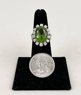 Cushion-Cut Platinum Peridot & Diamond Ring: in 18k gold and platinum setting. Approximate size 6 1/2. Peridot clear with fine color measures 15.2 by 11 by 8.2 mm within a border of 14 round diamonds each .10 pts, approximate diamond weight 1.40