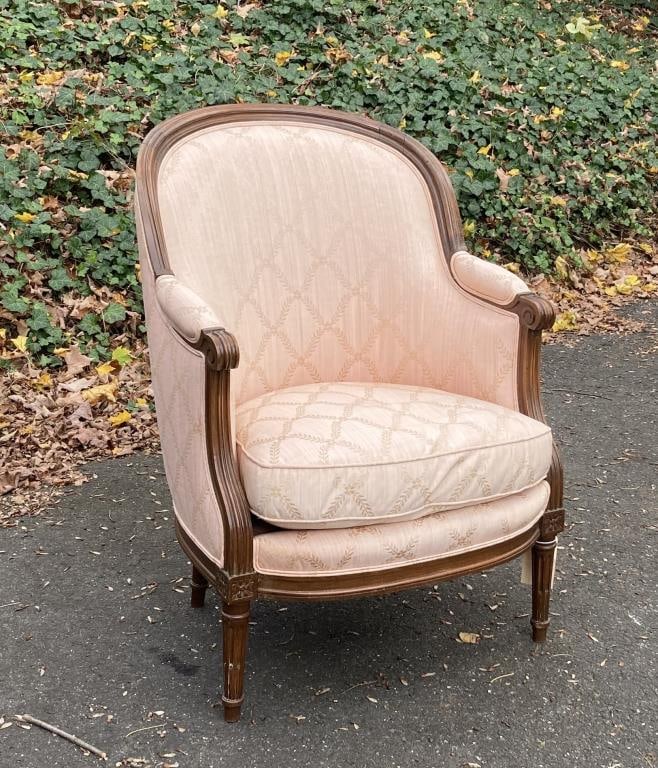 Louis XVI Style Carved Fruitwood Bergere Chair: with molded frame, rosette carved and fluted legs, late 19th century or later. 37 1/2" high, 25" wide, 24 1/4" deep, 17" seat height. Some minor surface wear to frame, upholstery not damaged.
