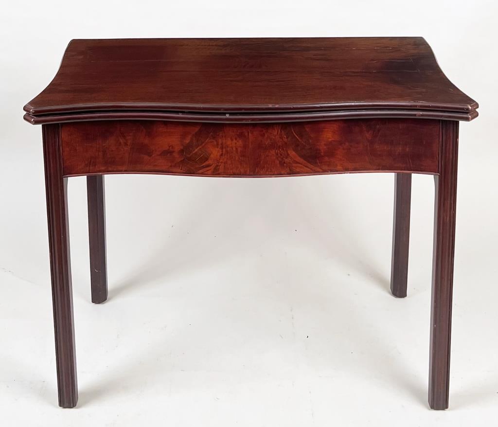 George III Serpentine Mahogany Game Table: fold over top with baize lined interior and inlaid cross-banding, molded legs,18th century. Closed: 29" high, 37" wide, 18" deep: open 37" wide, 37" deep. Cracks to veneer, back edge graze, repair to 