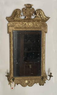 George II Carved Giltwood Mirror: with brass candle arm sconces and foliate cresting, possibly original beveled mirror plate. 51" high, 26" wide. Expected age and use wear, some minor losses to gesso and gilding.