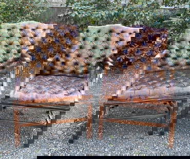 Pair Georgian Style Tufted Leather Library Chairs: with arched crest, upholstered arms and molded leg base with stretchers. 42" high, 27" wide, 24" deep. Seat height: 18.5". As is upholstery condition, one arm with later replaced leather, scuffs and t