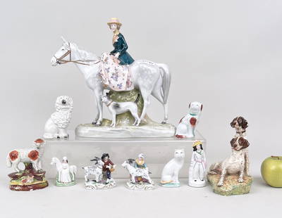 Ten Continental Porcelain Figurines: comprising Staffordshire dogs, sheep, two figures with goats, hunting spaniels, the largest a Capodimonte woman on horse. Largest: 11" high, 11 1/2" wide, 3" deep.