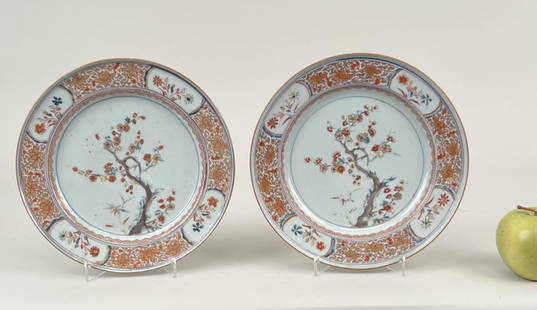 Two Chinese Polychrome & Gilt Porcelain Plates: with flowering prunus within a paneled blossom and vine border; double ring marks and old inventory labels to the underside. 9" diameter. One repaired.