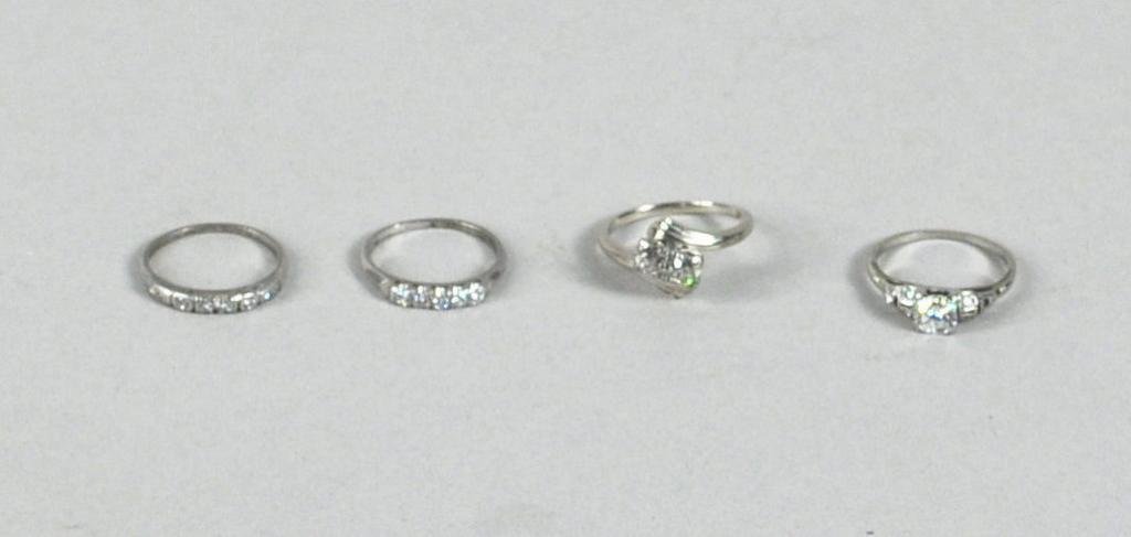 Group Four Ladies' Diamond Rings: Four diamond rings, comprising an 18K gold diamond solitaire (approx 1/2 carat), a 14K gold diamond solitaire (approx 1/4 carat), and two platinum bands set with small diamond stones. 8 dwt total incl