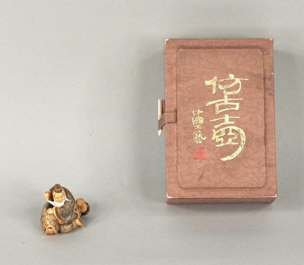 Finely Carved and Painted Ivory Netsuke: Finely carved and painted ivory netsuke, depicting an old man with a large fish, signed, in a fitted and signed box. 1 1/2" high, 1 3/4" wide.