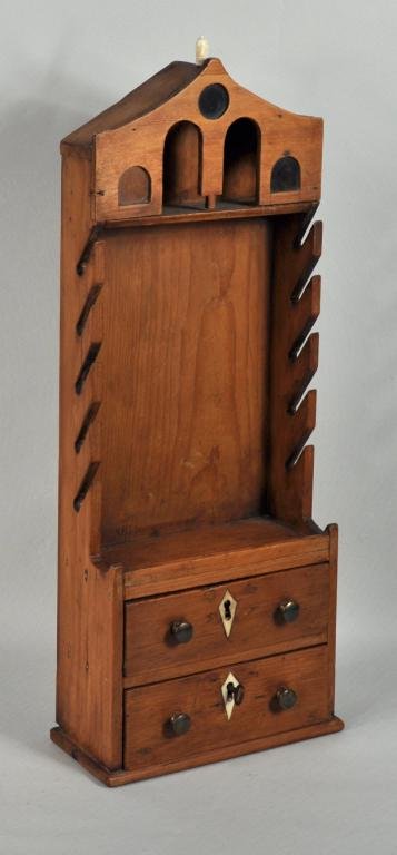 English Pine Architectural Pipe Box: English pine architectural form pipe box, with architectural pediment over a pipe rack and two lower drawers with ivory escutcheons. 22 1/2" high, 8 1/4" wide, 5" deep.