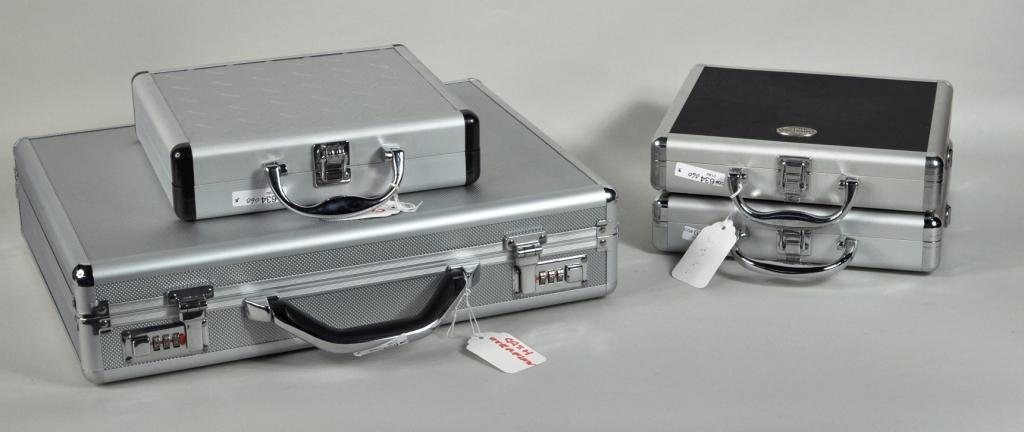 Group of Four Thompson Hard Sided Cases: Group of four Thompson hard sided cases, including a silver brief case and three smaller examples. Largest: 18" high, 14" wide, 4" deep; smallest: 9" high, 10" wide, 2" deep.