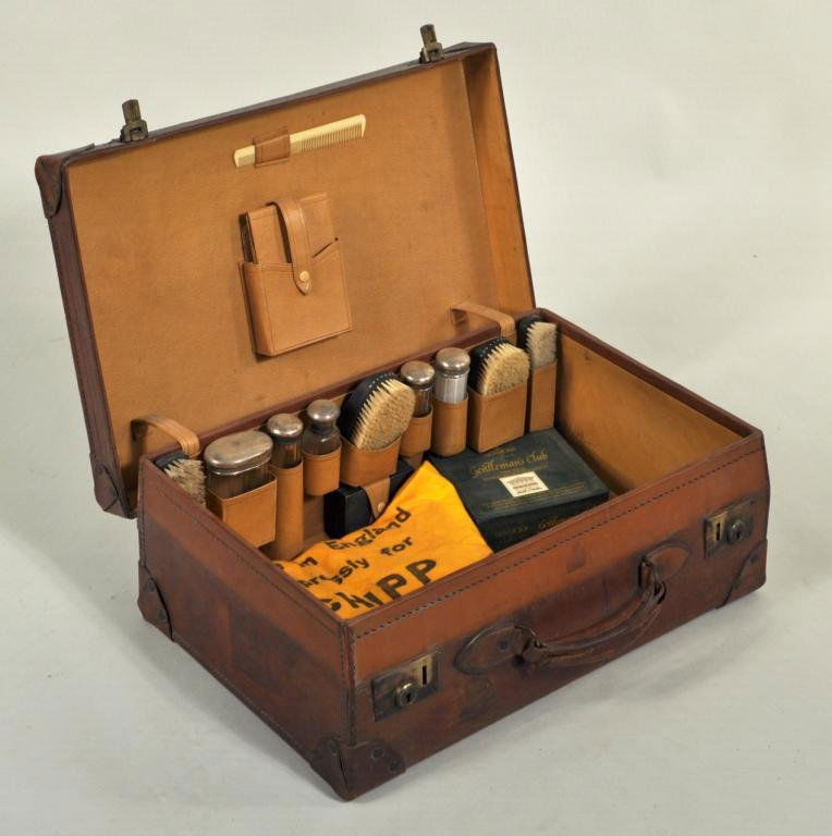 Vintage Fitted Leather Travel Case: Vintage leather travel case, the interior fitted with gentleman's accessories, including ebony brushes and silver lidded bottles. 14 1/2" high, 22 1/4" wide, 7 1/2" deep.