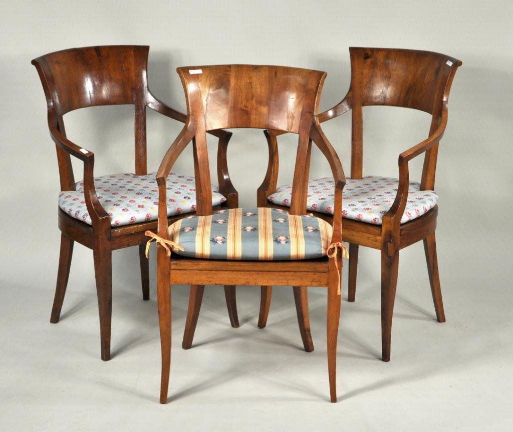 Three Biedermeier Walnut and Fruitwood Arm Chairs: Three Biedermeier walnut and fruitwood arm chairs, comprising a pair together with a corresponding single chair, all with tablet crests and caned seats. 34" high, 20 1/2" wide, 21 3/4" deep; seat heig