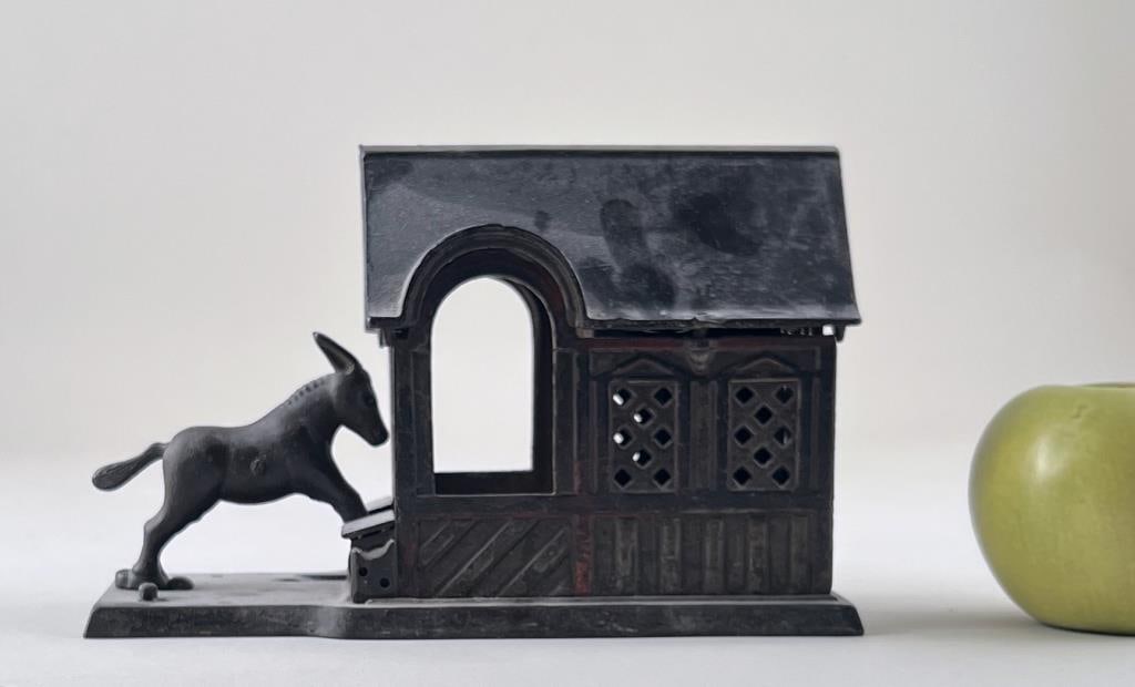 "Cast Iron Mule Enters Barn" Mechanical Bank: J.E. Stevens Co, 1880. 9" high, 6 3/4" wide, 3" deep. Oxidation, fading.