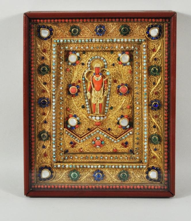 Nepalese Gilt Metal Mother of Pearl Inlaid Plaque: Nepalese gilt metal, mother of pearl, glass and stone inlaid plaque, circa 1900, depicting a deity holding a flower spray, other hand with upturned palm, framed, not examined out of frame. 10 1/4" hig