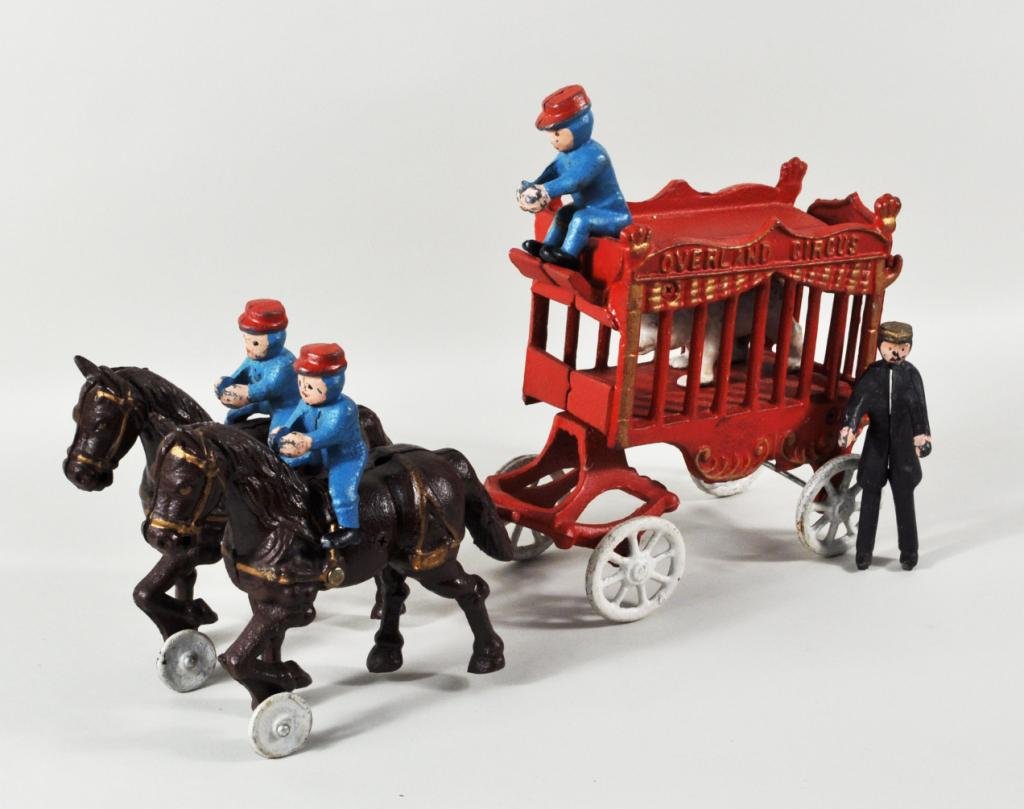 Cast Iron "Overland Circus" Toy: Cast iron "Overland Circus" toy, 20th century, comprising a horse drawn wagon with polar bear, driven by three seated figures and standing figure at back. Paint wear, loss, polar bear in two pieces. 3