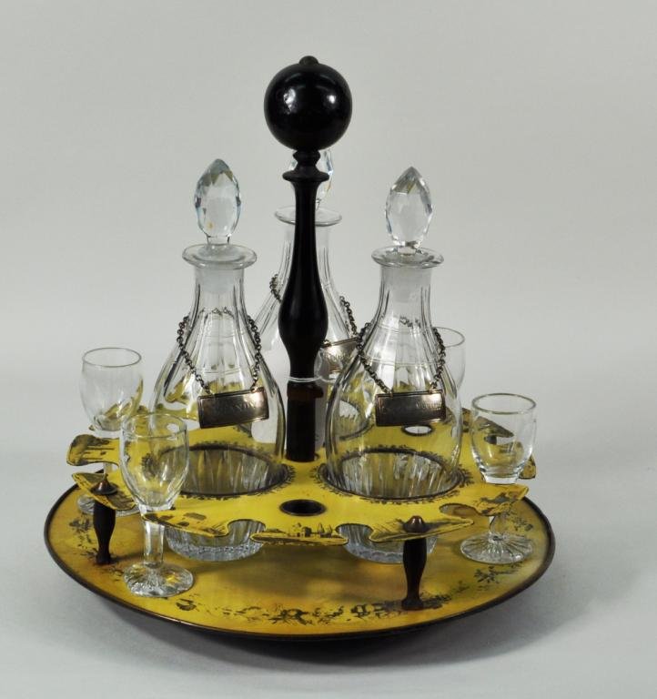 Tole, Wood & Crystal Decanter Set, Tole Wall Rack: Yellow tole, wood and crystal decanter set, 19th century, the tole lazy susan with transfer printed decoration holding three decanters with Ensko NY sterling liquor labels and four glass cordials, tog