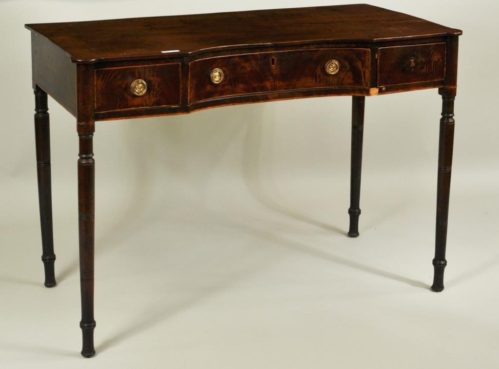 Sheraton Mahogany Writing Desk: Late George III sheraton design hollow front mahogany writing desk, with three working drawers, raised on turned legs. England, early 19th century. Some repairs and veneer losses. 30" high, 42 1/2" wi