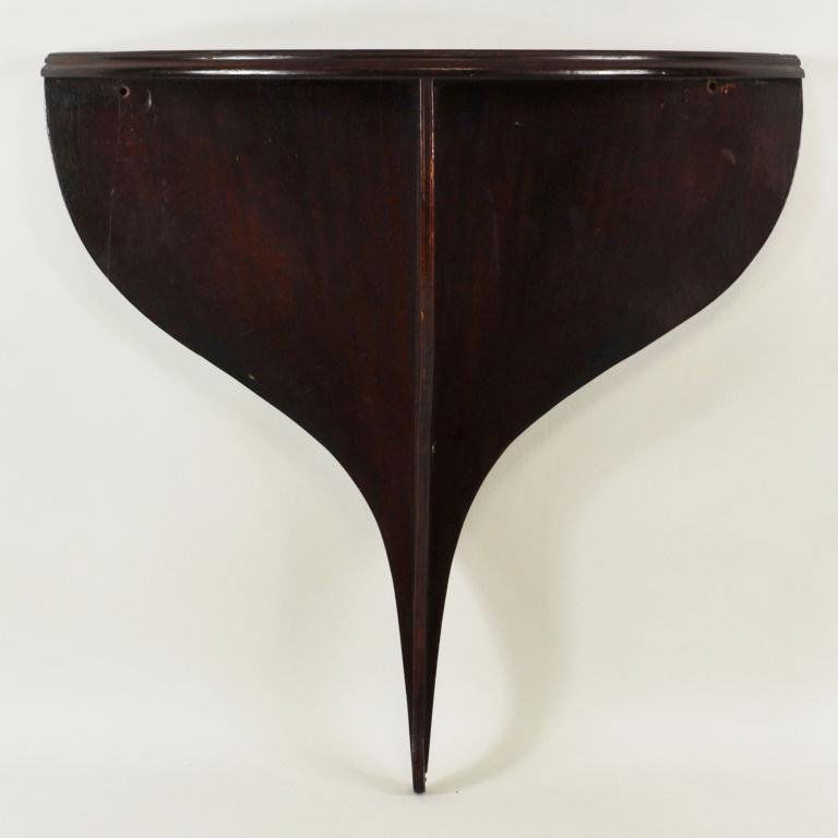 Georgian Mahogany Demilune Wall Bracket/Shelf: Georgian mahogany small wall bracket/shelf with demilune shelf and pierced vertical support mounted against a shaped back. England, 19th century. 21 1/4" high, 21 1/2" wide, 7 1/2" deep.