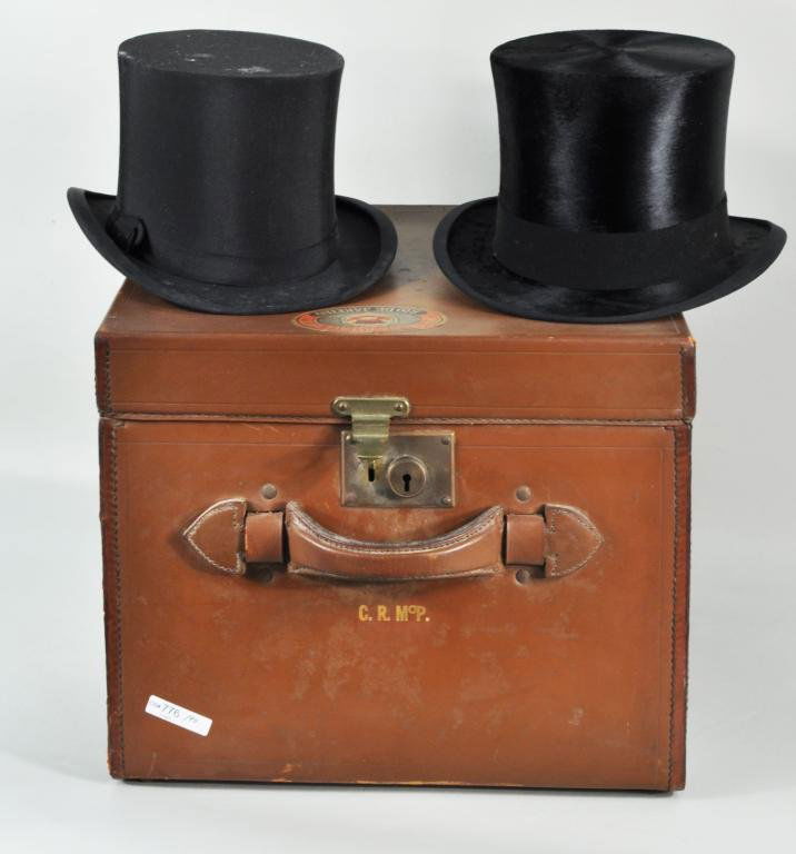 Leather Hat Box w/2 Knox Top Hats: A leather hat box containing two Knox top hats, one beaver, one silk, early 20th C. 6 1/2" high, 11 1/2" wide; 12 1/2" high, 15 1/2" wide Condition: use wear, stains, soiling, box with edge wear, soil