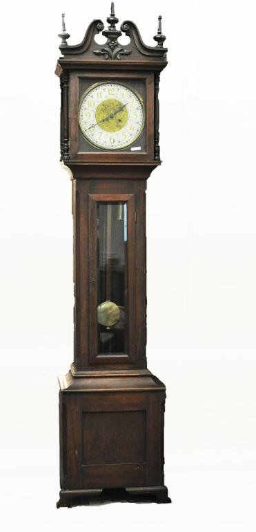 American Carved Mahogany Tall Case Clock: American Chippendale style carved mahogany tall case clock, New Haven Clock Company, the hood with carved tympanum, broken arch pediment, turned finials, the brass movement with engraved face with spa
