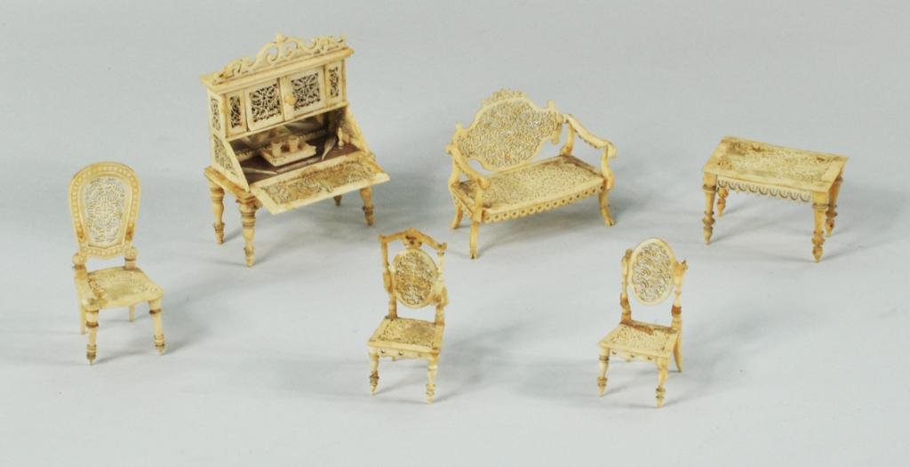 Asian/Anglo-Indian Set Carved Bone Doll Furniture: A possibly Asian or Anglo-Indian set of carved bone doll furniture, late 19th C, comprising a drop front desk with writing articles in interior, a settee, table and three chairs. Smallest: 2 1/4" high