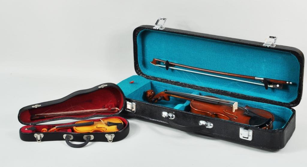 Two Cased Violins, One Sample, One Child's: Two cased violins, 20th C., with bows, comprising a salesman's sample and a Chinese "Antonius Strings" violin. Largest: 16" long, 5 1/2" wide; smallest: 8 3/4" long, 3 1/4" wide. Condition: use wear, 